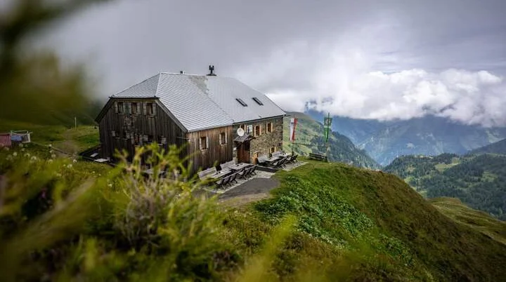 Berghütte mit Ausblick ins Tal und aufziehenden Wolken | © DAV/Wolfgang Ehn