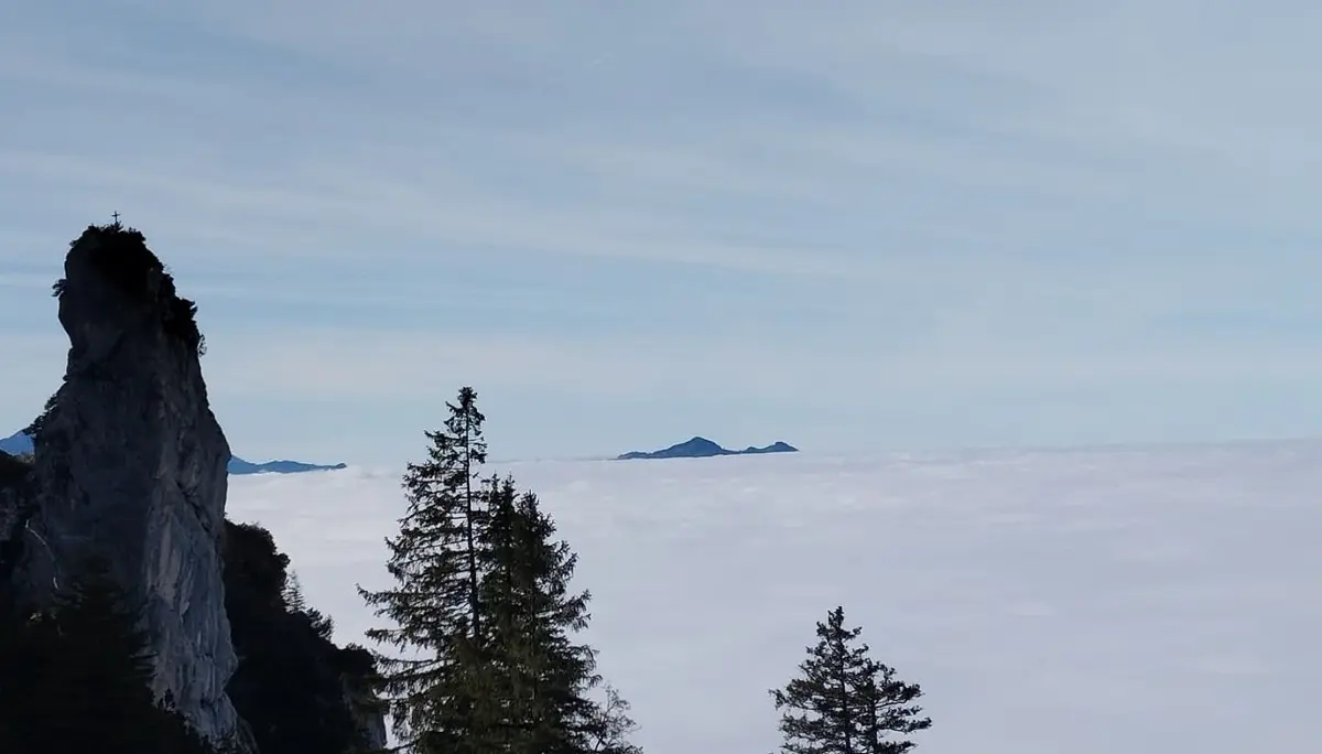 links Gipfelkreuz Spitzigschröfle - Nebel im Tal und im Hintergrund Alpspitze und Edelsberg | © Alena Srovnalova